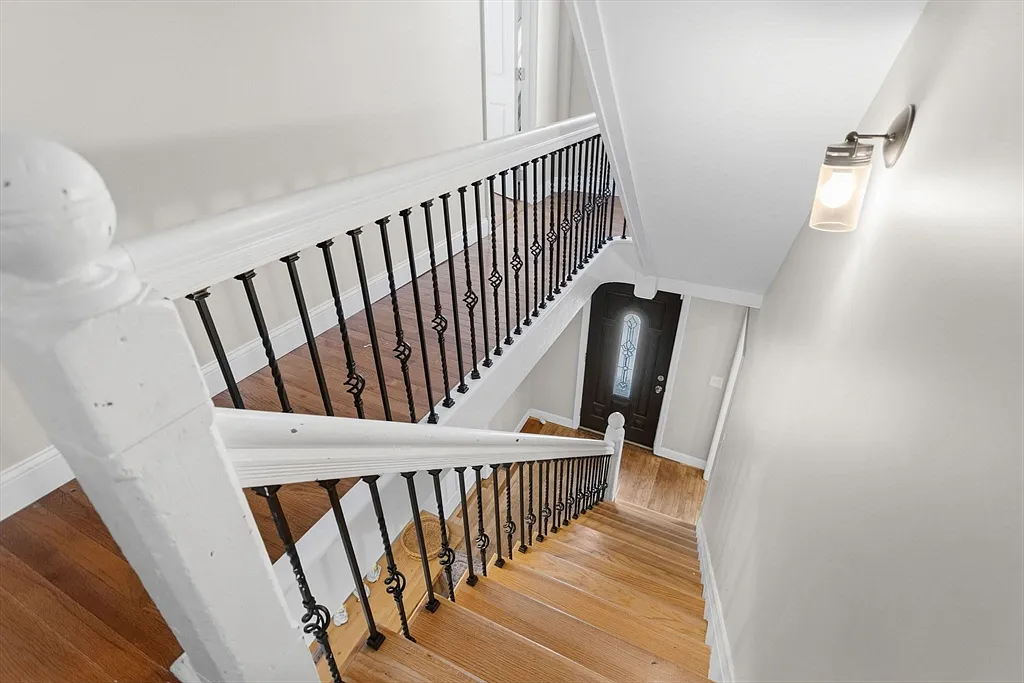 Wood staircase with white railings and black metal balusters
